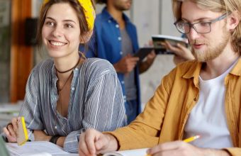 Lächelnde Studenten arbeiten im Café